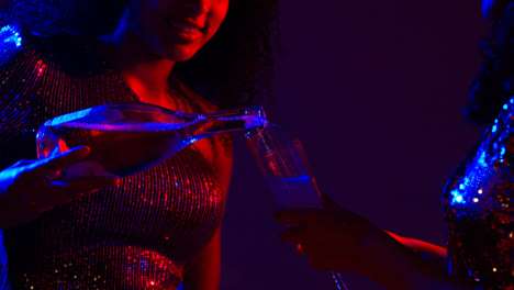Close-Up-Of-Two-Women-In-Nightclub-Bar-Or-Disco-Pouring-Drinks-From-Bottle